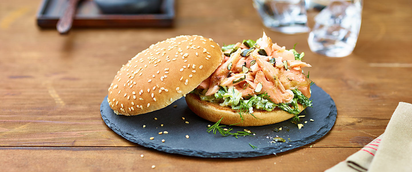 Ölz Maxi Burger Brötle mit „Pulled Lachs“, Schafkäse, Romanasalat, Rahmgurken & gerösteten Kürbiskernen