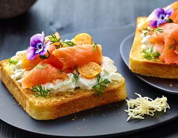 Ölz Butter Toast mit Räucherlachs, Veilchen, Physalis, Honig, Senfgurken, Ricotta & Dillkraut